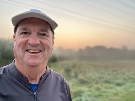A photograph of futurist Jim Carroll with a hazy sunrise in the back